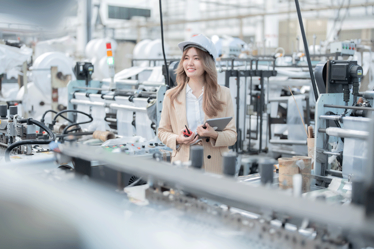 Frau guckt bei Produktion von Kunststoffgehäusen für Elektronik zu